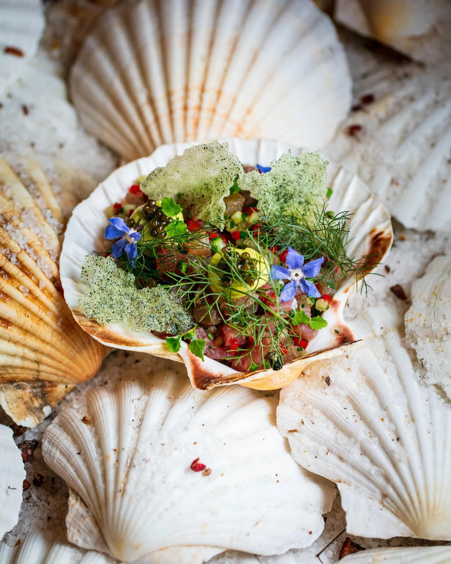 A garnished course served in a scallop shell